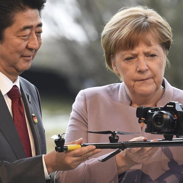 Angela Merkel und Shinzo Abe betrachten eine Kameradrohne.