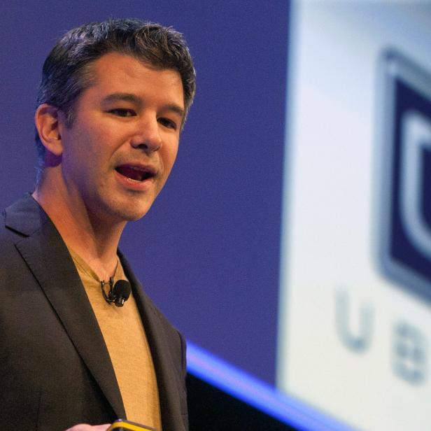 Travis Kalanick spricht auf einer Bühne vor einem Uber-Logo.