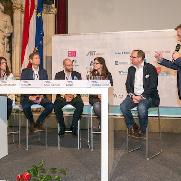 Eine Podiumsdiskussion auf dem M2M/IOT Forum mit mehreren Teilnehmern und einem Moderator.