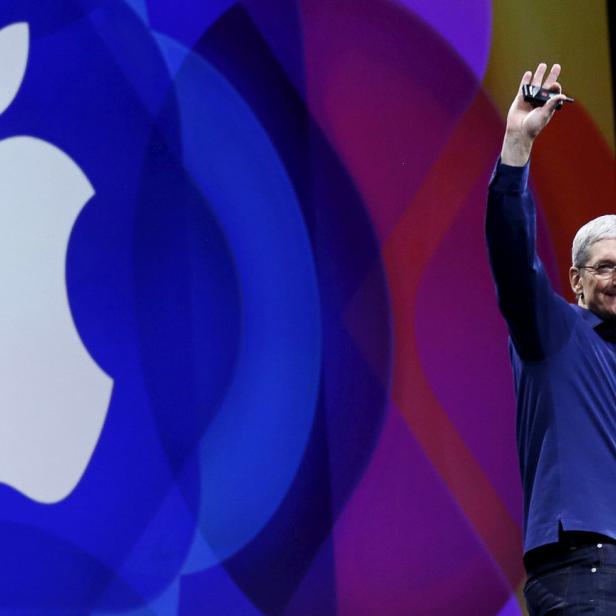 Tim Cook hält eine Rede vor dem Apple-Logo.