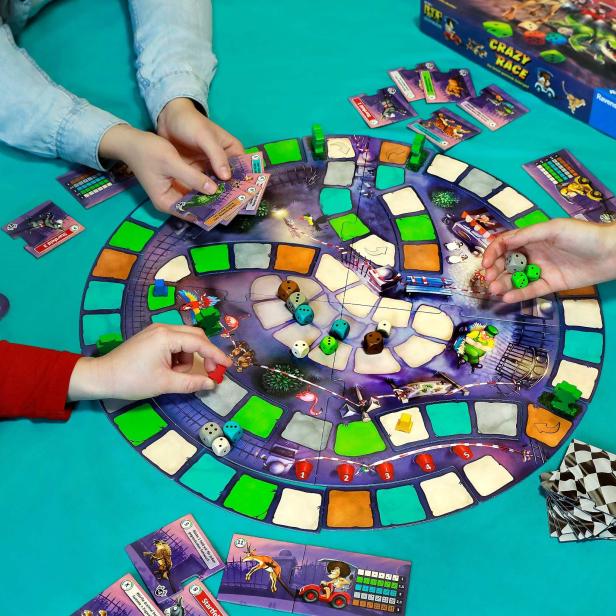 Mehrere Personen spielen das Brettspiel „Crazy Race“ von Ravensburger.