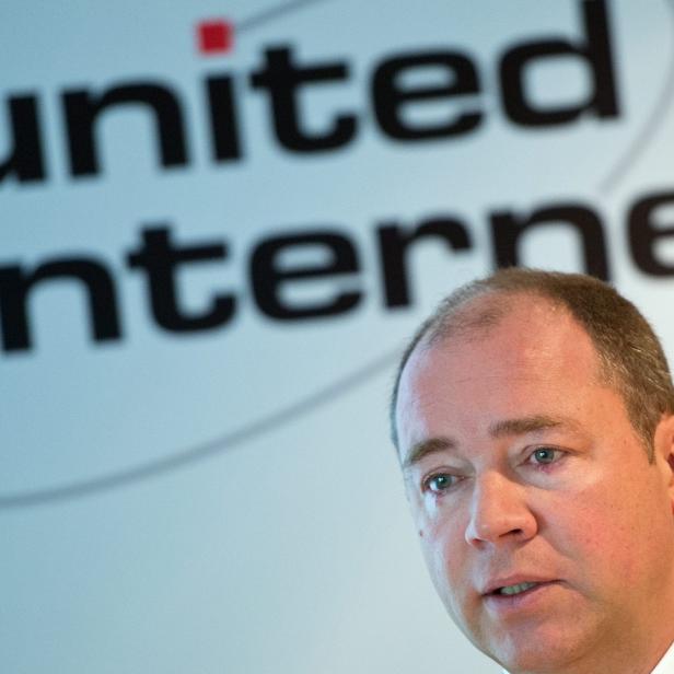 Ein Mann spricht vor einem „United Internet“-Logo.