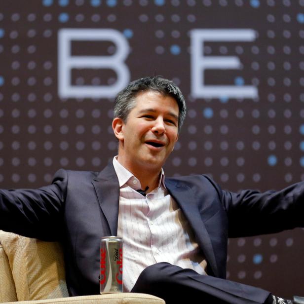 Travis Kalanick, ehemaliger CEO von Uber, gestikuliert vor einem Uber-Logo.