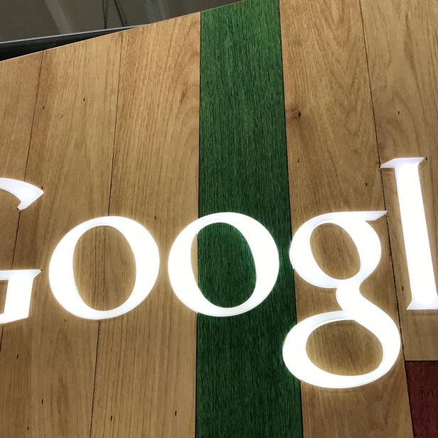 Das Google-Logo auf einer hölzernen Wand mit grünen Akzenten.