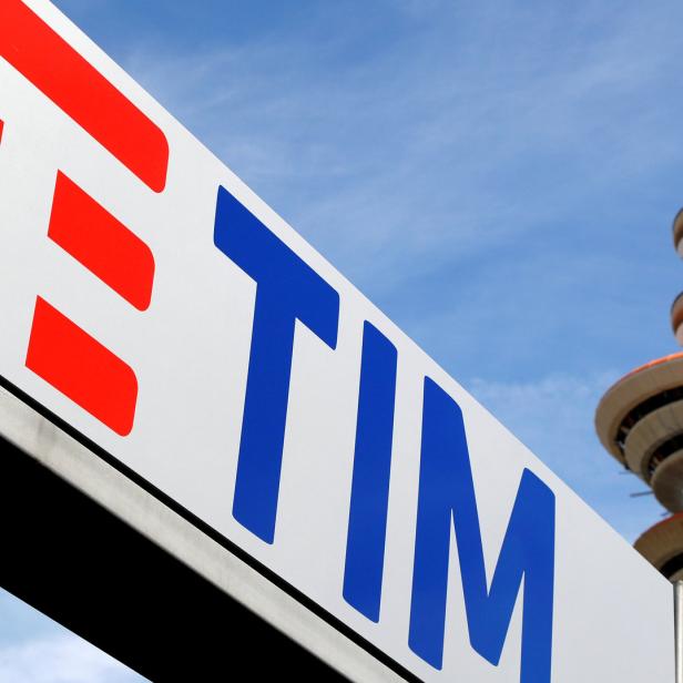 Das TIM-Logo vor einem Telekommunikationsturm unter blauem Himmel.