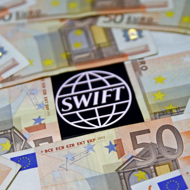 Das SWIFT-Logo liegt auf einem Haufen von 50-Euro-Scheinen.