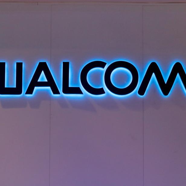 Das blaue, leuchtende Qualcomm-Logo an einer Wand.