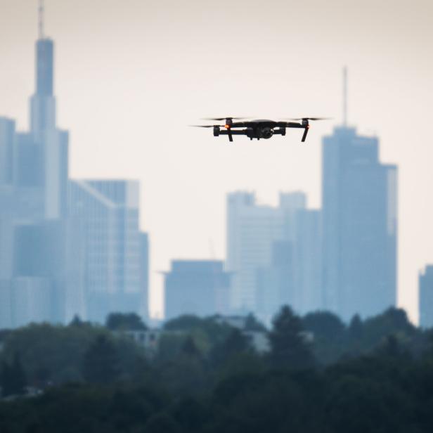 ABD0003_20170828 - Eine Drohne fliegt am 27.08.2017 in Frankfurt am Main (Hessen) auf dem Lohrberg scheinbar über den Hochhäusern der Stadt, die allerdings einige Kilometer entfernt im Bankenviertel stehen. Foto: Frank Rumpenhorst/dpa +++(c) dpa - Bildfunk+++