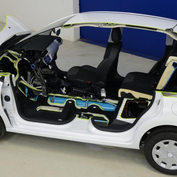 Ein weißes Auto wurde aufgeschnitten, um die innere Struktur und die Bauteile zu zeigen.