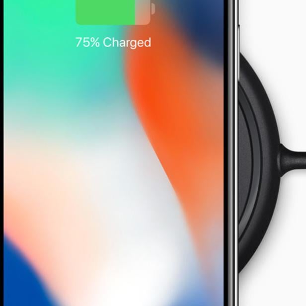 Ein iPhone liegt auf einer kabellosen Ladestation und zeigt 75% Akkuladung an.