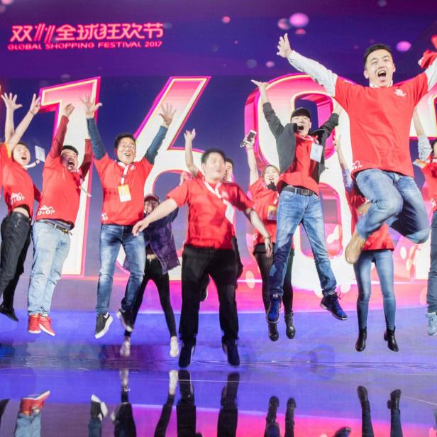 Eine Gruppe von Menschen springt jubelnd auf einer Bühne während des „Global Shopping Festival 2017“.