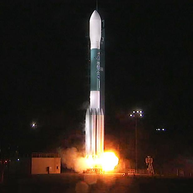 Eine Rakete startet bei Nacht mit hellem Feuerschein.