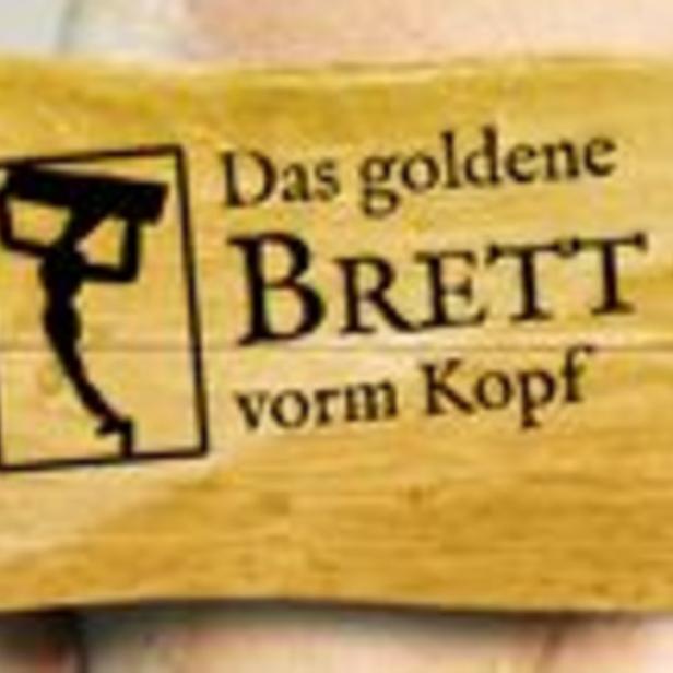 Ein Holzschild mit der Aufschrift „Das goldene BRETT vorm Kopf“.