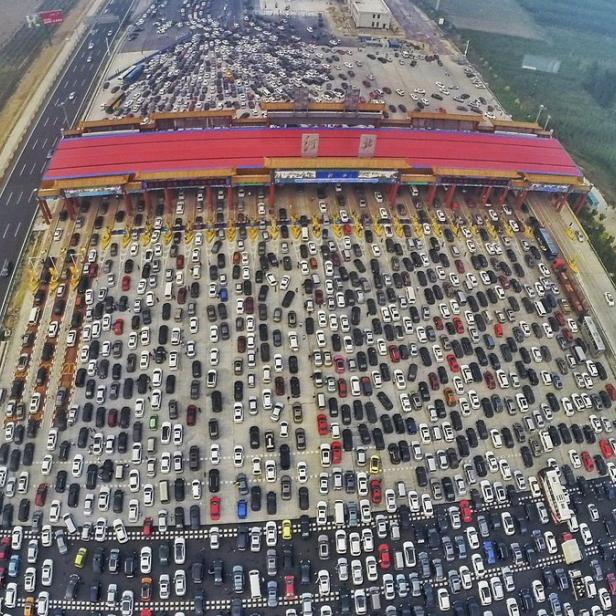 Vehicles are seen stuck in a traffic jam near a toll station as people return home at the end of a week-long national day holiday, in Beijing, China, October 6, 2015. Picture taken October 6, 2015. REUTERS/China Daily CHINA OUT. NO COMMERCIAL OR EDITORIAL SALES IN CHINA