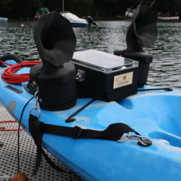 Ein blaues Kajak mit schwarzer Ausrüstung liegt auf einem Steg.