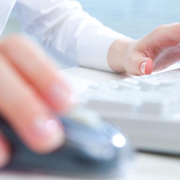 Detail of female hands using a computer on office background