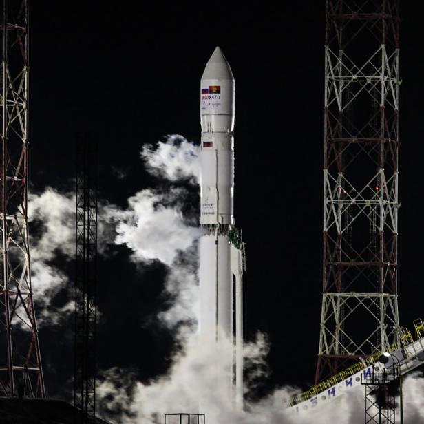 Eine Rakete startet bei Nacht mit viel Rauch und Feuer.