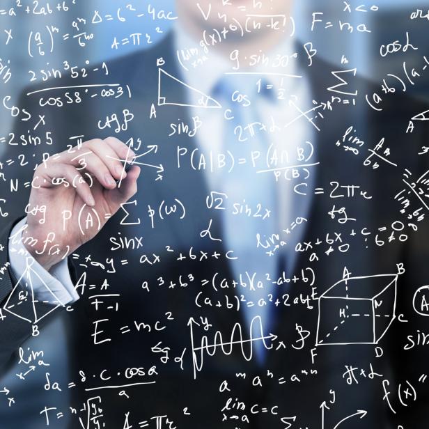 Eine Person schreibt mit einem Stift mathematische Formeln auf eine transparente Oberfläche.