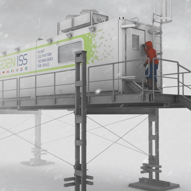 Eine Person betritt im Schneefall das EDEN ISS-Gewächshaus, eine Anlage für Weltraumforschung.