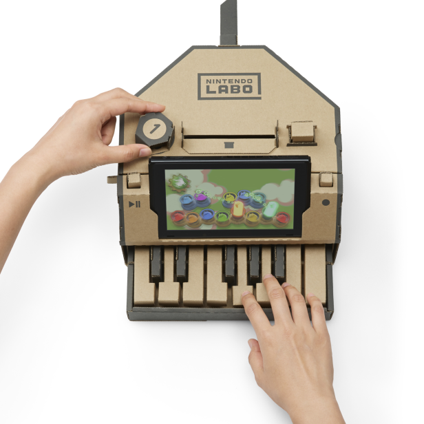 Eine Person spielt auf einem Nintendo Labo Pappklavier.