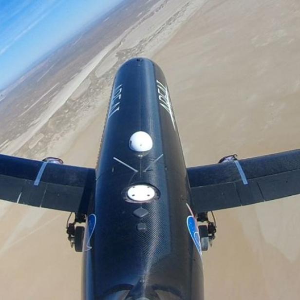 Blick von einem Flugzeug auf eine Küstenlandschaft.
