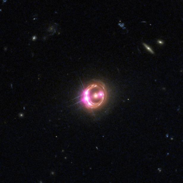 Eine Galaxie erscheint als leuchtender Ring mit einem hellen Zentrum vor einem dunklen Hintergrund.