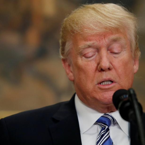 U.S. President Donald Trump signs a presidential proclamation placing tariffs on steel and aluminum imports while surrounded by workers from the steel and aluminum industries at the White House in Washington