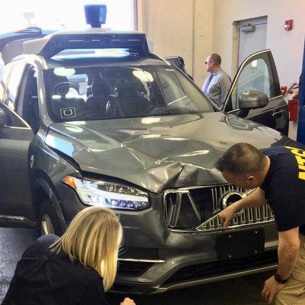 FILE PHOTO: NTSB investigators examine a self-driving Uber vehicle involved in a fatal accident in Tempe