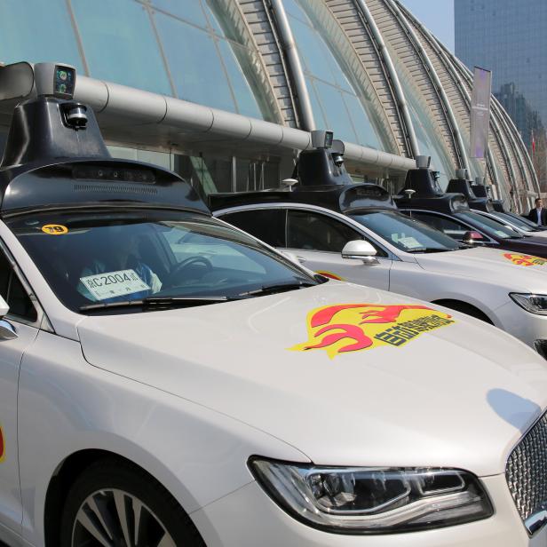 Baidu's Apollo autonomous cars are seen during a public road test for self-driving vehicles in Beijing