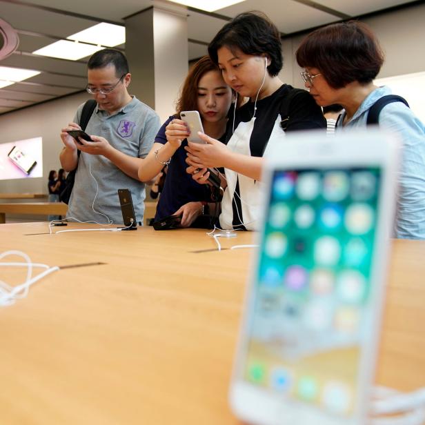 FILE PHOTO: Customers look at  Apple's new iPhone 8 Plus after it goes on sale at an Apple Store in Shanghai