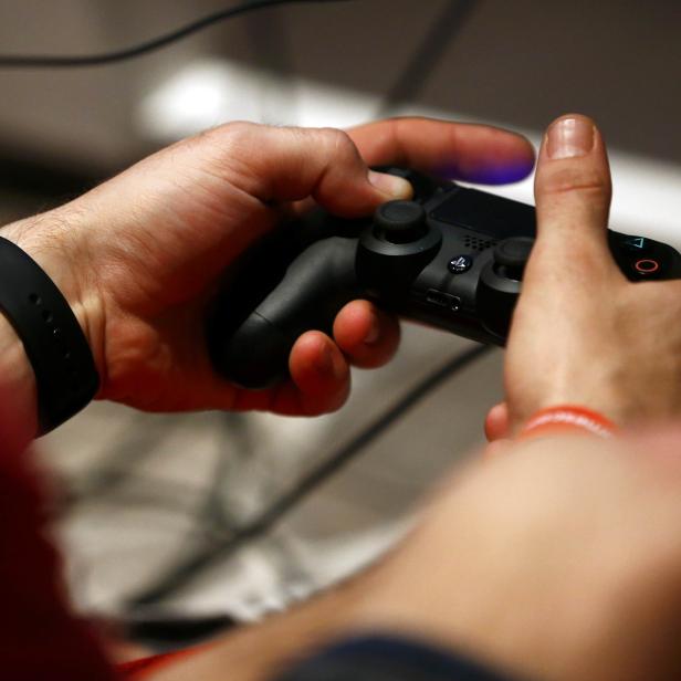 A man uses a Sony PlayStation controller during the Gamescom 2015 fair in Cologne