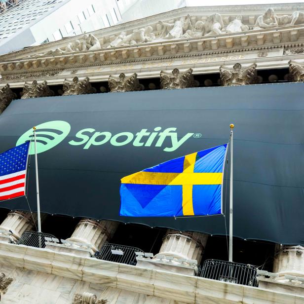 The Spotify logo hangs on the facade of the New York Stock Exchange with U.S. and Swedish flags as the company lists its stock with a direct listing in New York