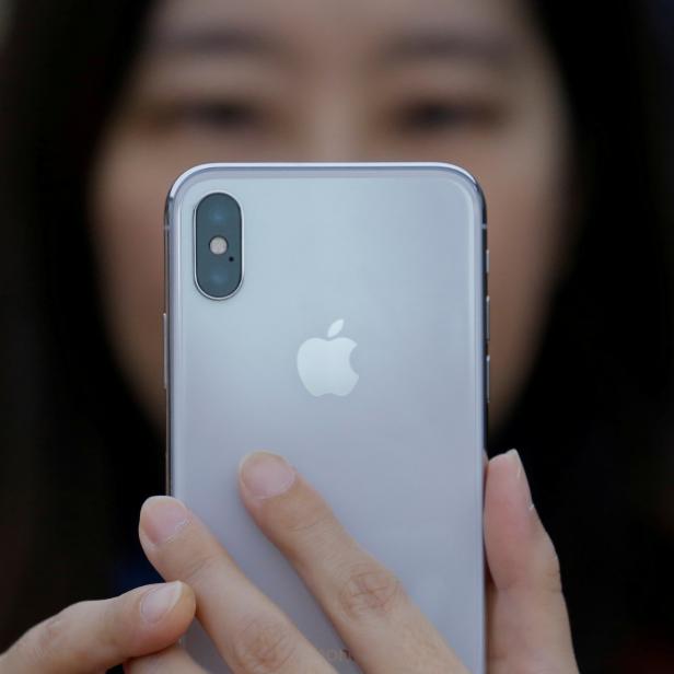 FILE PHOTO: A attendee uses a new iPhone X during a presentation for the media in Beijing