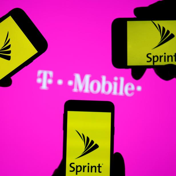 A smartphones with Sprint logo are seen in front of a screen projection of T-mobile logo, in this picture illustration