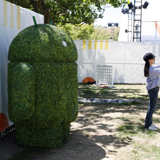 An attendee takes a photo with a Google Android mascot during the annual Google I/O developers conference in Mountain View, California