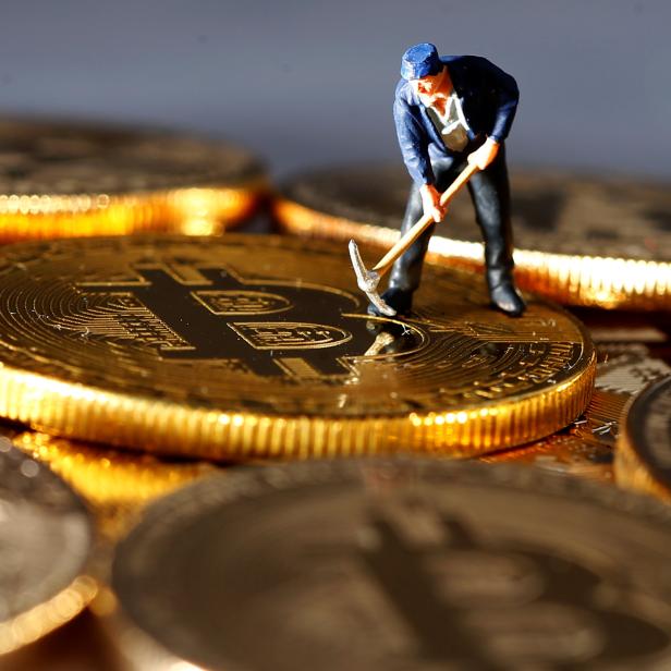 A small toy figure is seen on representations of the Bitcoin virtual currency in this illustration picture