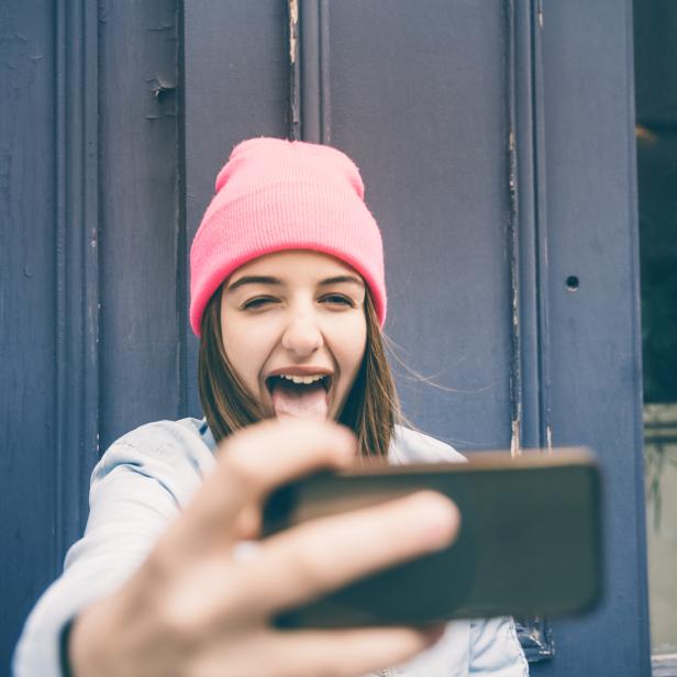 Teenager girl make selfie and making grimaces