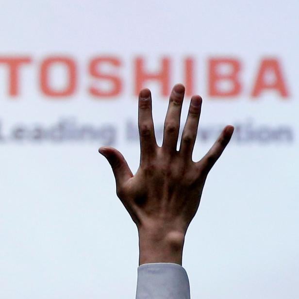 FILE PHOTO: FILE PHOTO: A reporter raises his hand for a question during a news conference at the Toshiba Corp company headquarters in Tokyo, Japan