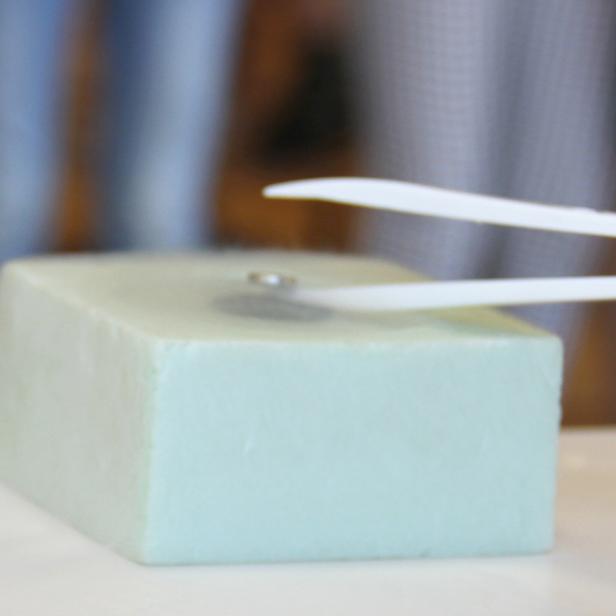 Eine Pinzette hält einen Supraleiter.