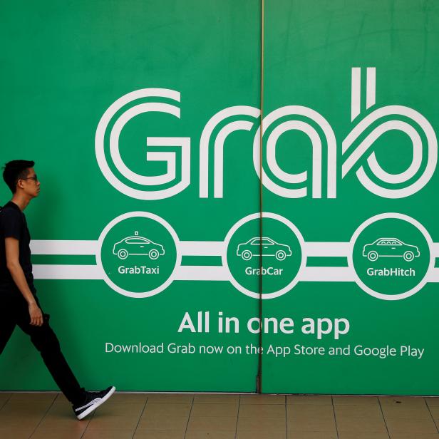 FILE PHOTO: A man walks past a Grab office in Singapore