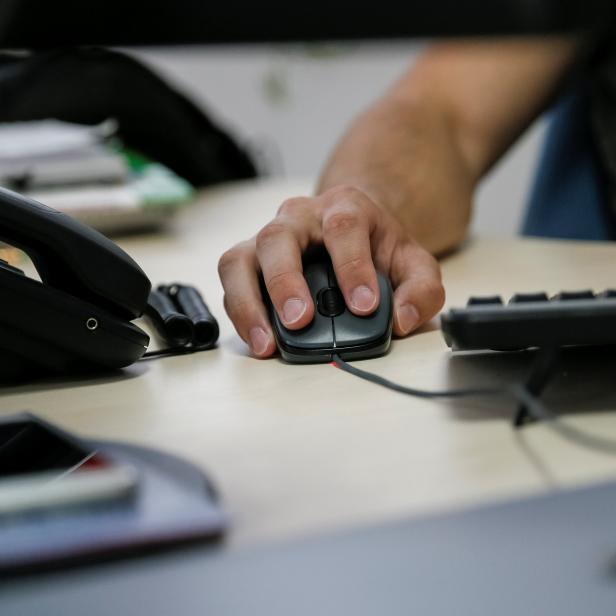 A specialist of IT company Infopulse uses a computer mouse in his office in Kiev