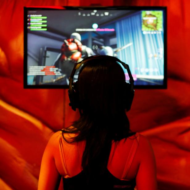 A female attendee plays a video game at E3, the world's largest video game industry convention in Los Angeles