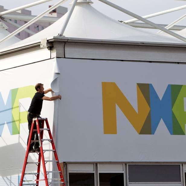 FILE PHOTO: A man works on a tent for NXP Semiconductors in preparation for the 2015 International Consumer Electronics Show (CES) at Las Vegas Convention Center in Las Vegas