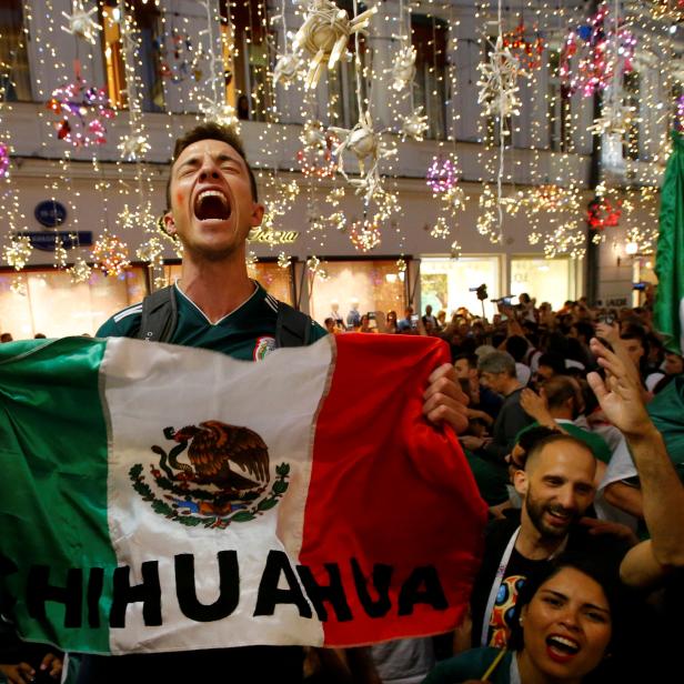 Jubelnde mexikanische Fans feiern mit einer Flagge den Sieg gegen Deutschland bei der Fußball-Weltmeisterschaft.