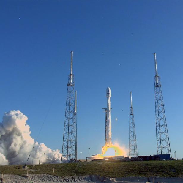 Eine Rakete startet mit einer großen Rauchwolke in den Himmel.