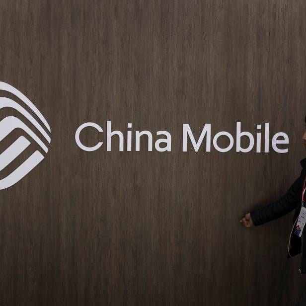 A man walks past the China Mobile logo at the Mobile World Congress in Barcelona