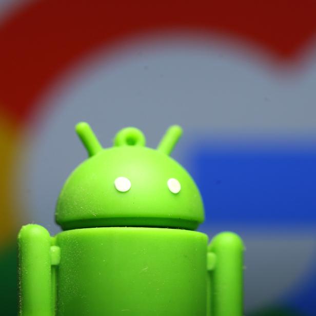 A 3D printed Android mascot Bugdroid is seen in front of a Google logo in this illustration