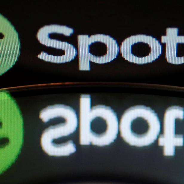 Illustration picture of the logo of online music streaming service Spotify reflected in an audio music CD