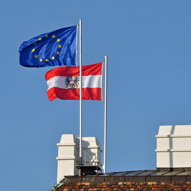 Die Europaflagge und die österreichische Flagge wehen auf einem Dach.