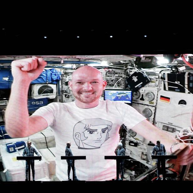 Kraftwerk spielt ein Konzert mit einem Astronautenbildschirm im Hintergrund.